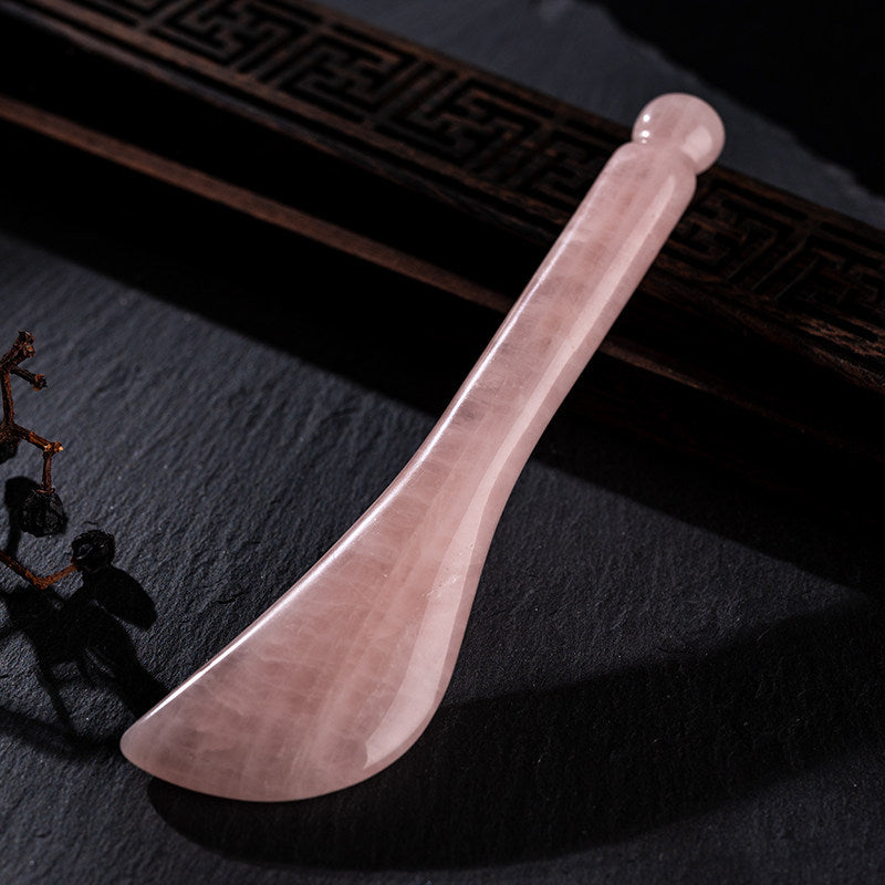 Rose quartz facial roller being used for a skincare massage